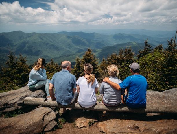 group of people sitting on rocks overlooking mountain